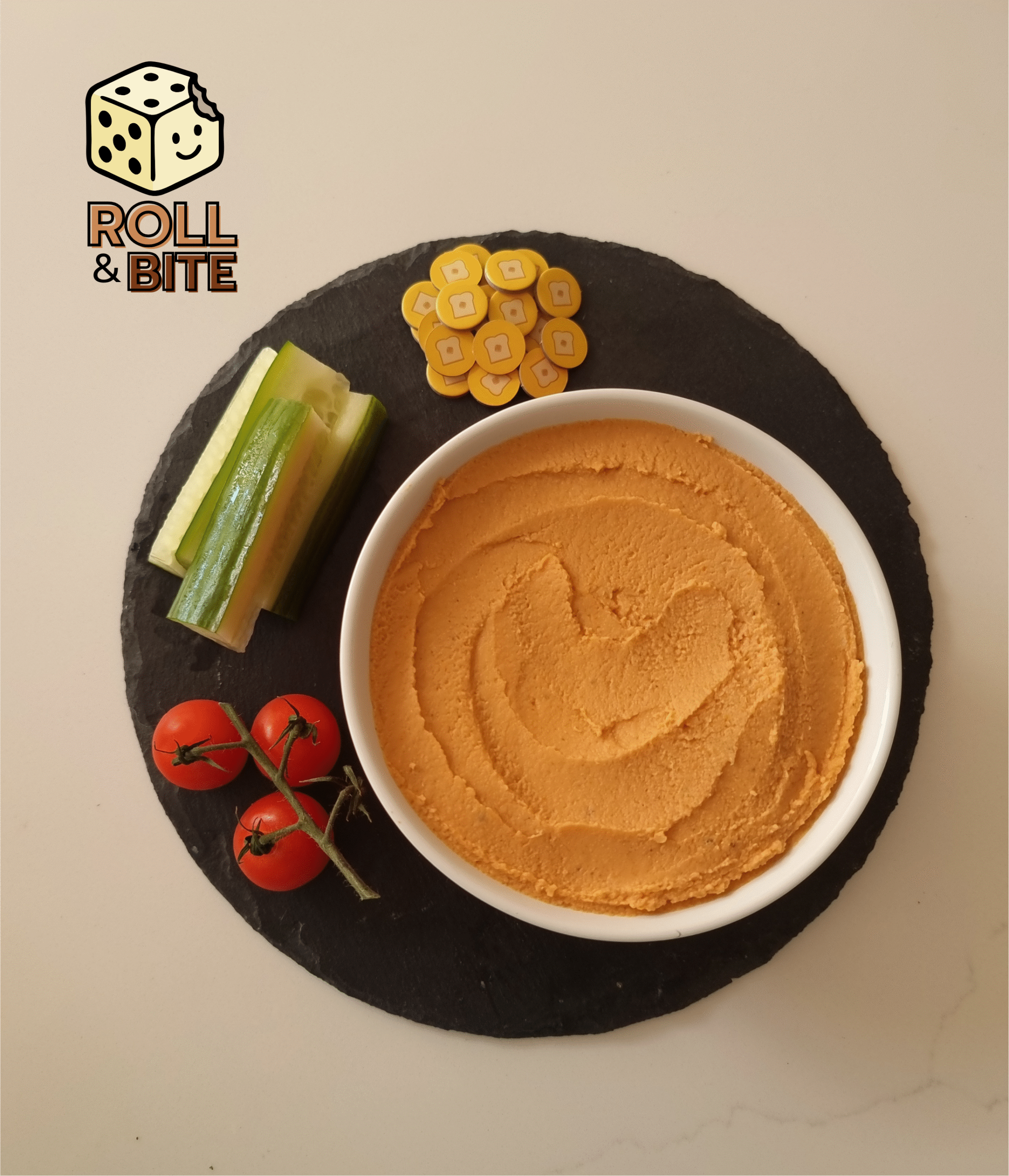 Sundried tomato hummus in a bowl with a side of cucumbers and cherry tomatoes.